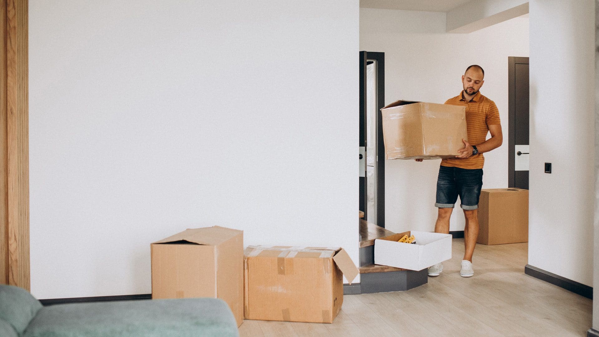 man moving boxes inside the home