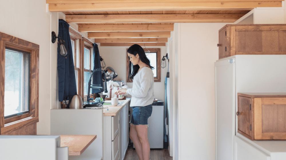 woman preparing a drink on the counter of a small home